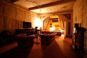 Bagnara di Romagna洛坎达迪巴尼雅拉酒店的客厅配有沙发、椅子和电视