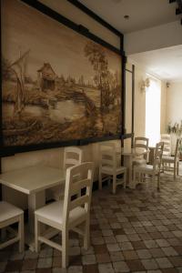 切尔诺夫策乔治帕勒斯酒店的一间设有桌椅的房间和墙上的绘画