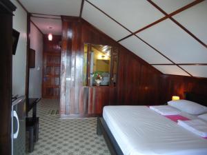 卡农奈帕罗海滩海风楼酒店的一间卧室配有一张木墙床