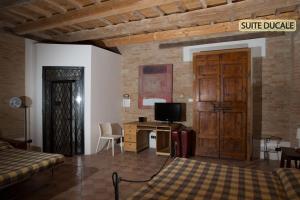 科里纳尔多Hotel Palazzo Meraviglia Albergo diffuso的一间卧室配有一张床和一张书桌及电视