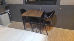 釜山普林斯汽车旅馆的一张小桌子和两把椅子,旁边是一张床