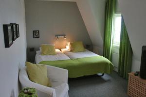 厄勒格伦德Strandhotellet的客房设有两张床、一张沙发和一个窗口。