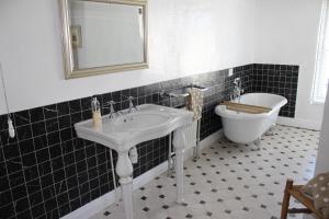 邓斯特The Olde House的一间带水槽、浴缸和卫生间的浴室
