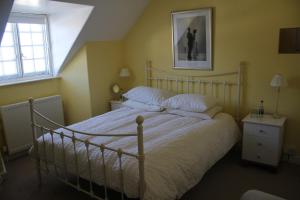邓斯特The Olde House的一间卧室配有一张带白色床单的大床