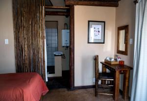 Twee RivierenXaus Lodge的卧室配有床、桌子和门