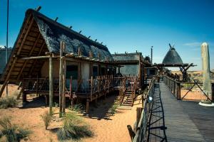 Twee RivierenXaus Lodge的沙漠中一座茅草屋顶的建筑