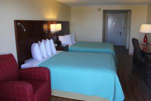 芬威克岛Seaside Inn & Suites的酒店客房带两张床和一张红色沙发