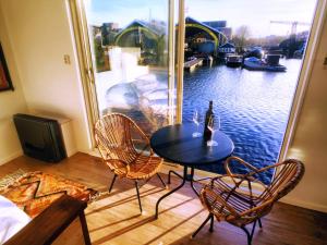 阿姆斯特丹迪亚船屋住宿加早餐旅馆的阳台上配有桌椅和一瓶葡萄酒