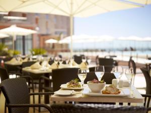 奥良里尔滨海酒店及水疗中心的餐桌,带餐盘和酒杯