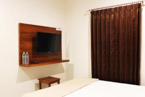 泗水达尔玛万民宿的一间卧室配有一张床,墙上配有电视