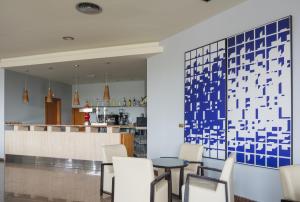 多列毛利诺斯皇家海岸酒店的餐厅设有白色椅子和蓝色的墙壁