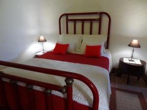 富尔纳斯Casa do Rei的一间卧室配有一张带红色枕头的大床