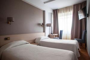 佩里洛布里亚尔酒店的酒店客房设有两张床和窗户。