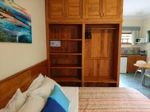 伊利亚贝拉Galápagos ApartHotel的一间卧室配有一张床和一个橱柜,还设有一间厨房