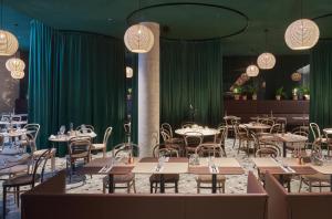 卑尔根桑德尔K酒店的用餐室配有桌椅和绿色窗帘