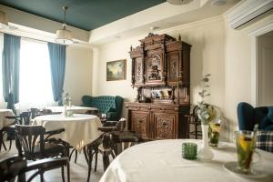 文尼察丘池尔酒店的一间带两张桌子和大型木制橱柜的餐厅