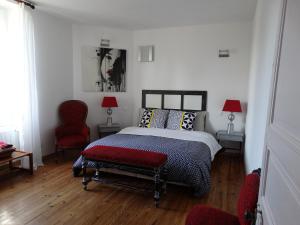 Saint-Vincent-de-Paul伯格罗斯酒店的一间卧室配有一张床和一张红色椅子