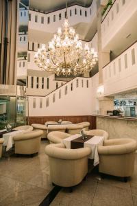 尼特拉Grand Hotel Sole的一个带椅子和吊灯的大型大堂
