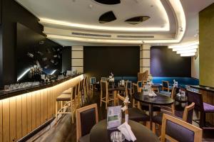 迪拜星霖罗拉酒店的一间带桌椅的餐厅和一间酒吧