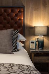 贝克斯希尔The Driftwood Bexhill的一间卧室配有一张带灯和时钟的床