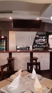锡纳亚阿克苏**旅馆的一间设有两张桌子的用餐室和一间酒吧