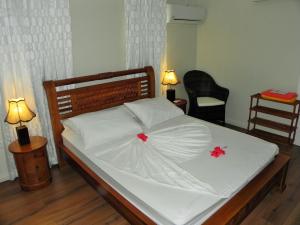 马埃岛贝拉扎尔区山畔别墅的一张铺有白色床单和红色鲜花的床