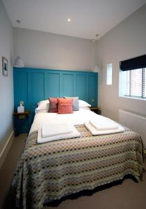 Potton驿站酒店的一间卧室配有一张大床和蓝色床头板