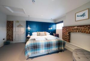 Potton驿站酒店的一间卧室配有一张带蓝色墙壁的大床