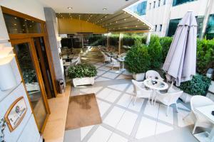 地拉那科托尼精品酒店的一个带桌椅和遮阳伞的户外庭院。