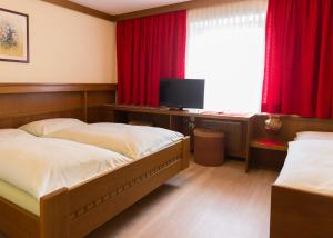 赫尔兴格斯曼德福宾馆的一间卧室配有两张床和一张书桌及电视