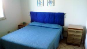帕洛港Appartamento Santangelo的一间卧室配有蓝色的床和床头柜