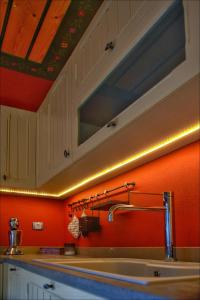 马克里尼撒Volos View Residence的厨房里设有一个水槽,厨房里设有橙色的墙壁