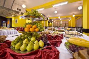旧柳博夫尼亚Hotel SOREA ĽUBOVŇA的自助餐,水果和蔬菜在餐桌上