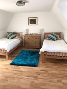 弗福尔Smithy House的一间带两张床的卧室和蓝色地毯