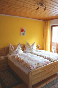 奥布施泰希施魏格尔豪斯住宿加早餐旅馆的卧室内的一张床位,卧室的墙壁为黄色