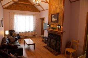 Snow LakeBluenose Bed & Breakfast的带沙发和壁炉的客厅