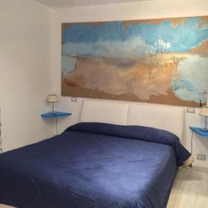 索伦托我的套房索伦托酒店的卧室配有蓝色的床和墙上的绘画作品