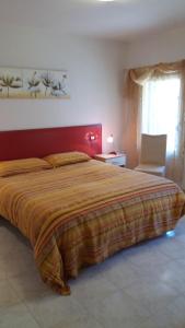 博尔索-德尔格拉帕萨尔维亚蒂莫假日公寓的一间卧室配有一张大床和红色床头板