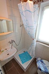 瓦伦Ferienwohnung Waren SEE 8211的浴室配有淋浴帘和盥洗盆。