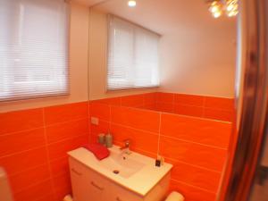 Kingston Beach温莎度假屋的浴室设有橙色瓷砖墙壁和水槽