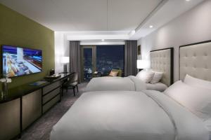 釜山百乐达斯釜山酒店的酒店客房设有两张床和电视。