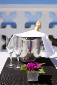 卡拉瓦德亚村庄酒店的一张桌子,上面放着两杯酒和一朵紫色的花