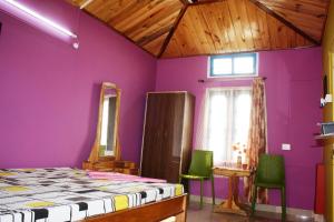 古瓦哈提Eagle Nest Home Stay的一间卧室设有紫色墙壁和绿色椅子