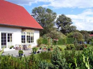 克劳斯多夫Ferienwohnungen Klausdorf VORP 940的白色的房子,有红色的屋顶和花园