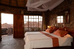 KanebisGondwana Canyon Lodge的一间带一张大床的卧室,位于带窗户的房间内