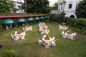 加尔各答Kenilworth Hotel, Kolkata的一组桌子,上面有鲜花,放在院子里