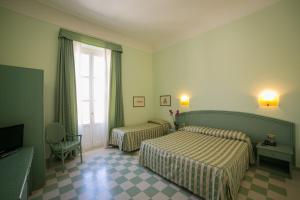 锡拉库扎Gran Bretagna Boutique Hotel Ortigia的酒店客房设有两张床和窗户。
