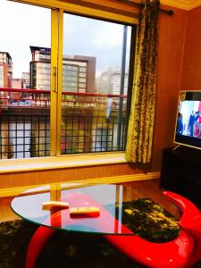 格拉斯哥Glasgow City Centre Flat with River Views and Parking的客厅设有玻璃桌和窗户