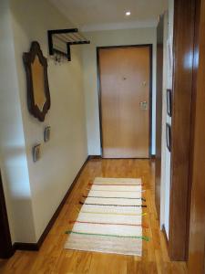 马托西纽什Porto 1 Bedroom Beach Apartment的走廊上设有门,木地板上铺着地毯