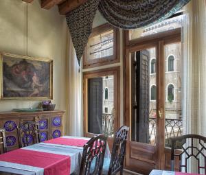 威尼斯圣菲尔米诺住宿加早餐酒店的一间带桌子和窗户的用餐室